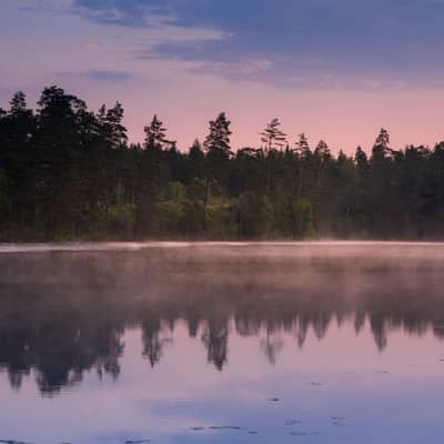 Glimrande morgon över stilla vatten